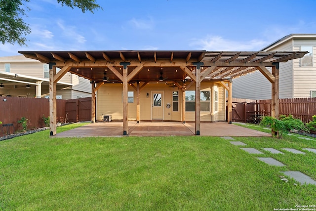 back of house with a lawn, a fenced backyard, ceiling fan, and a pergola