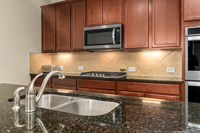 205 Wickersham, Boerne, TX 78015 - kitchen featuring a sink, decorative backsplash, dark stone counters, and stainless steel appliances