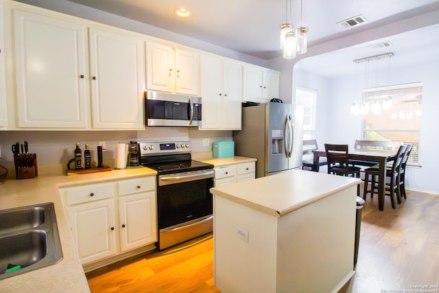 5315 Argyle, San Antonio, TX 78247 - kitchen featuring appliances with stainless steel finishes, a sink, light countertops, light wood-style flooring, and visible vents