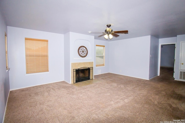 5315 Argyle, San Antonio, TX 78247 - unfurnished living room featuring a ceiling fan, visible vents, a tiled fireplace, baseboards, and carpet flooring