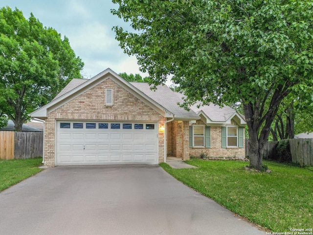 ranch-style house featuring driveway, a front yard, brick siding, fence, and an attached garage