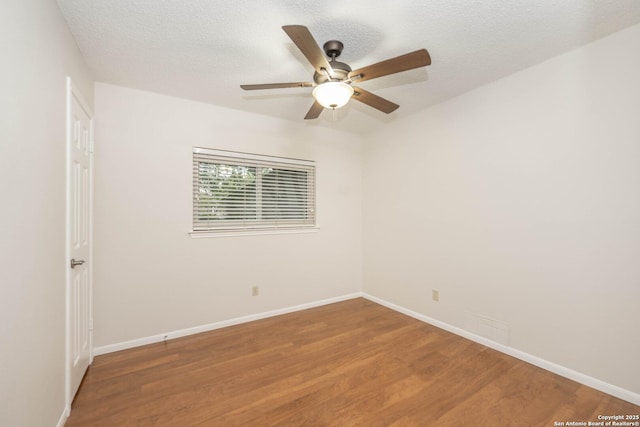spare room with baseboards, a ceiling fan, and wood finished floors
