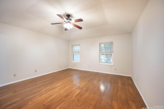 spare room featuring a textured ceiling, baseboards, a ceiling fan, and wood finished floors