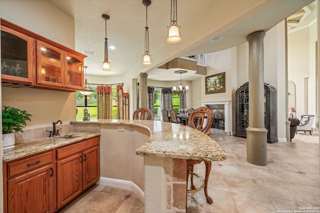 kitchen with a notable chandelier, a sink, visible vents, and light stone counters
