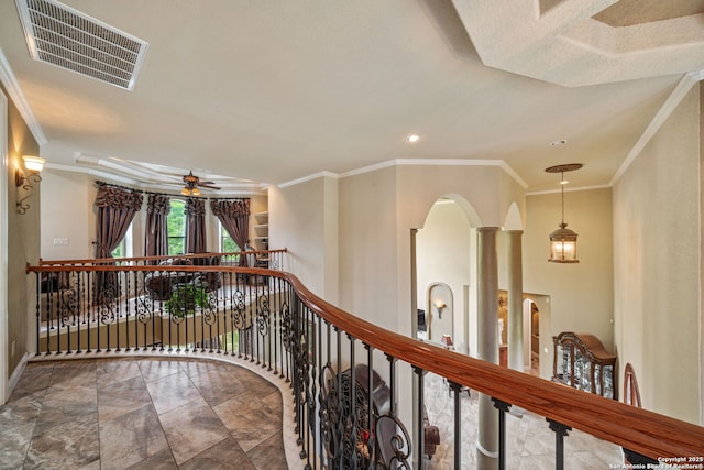 hallway featuring crown molding, arched walkways, and visible vents