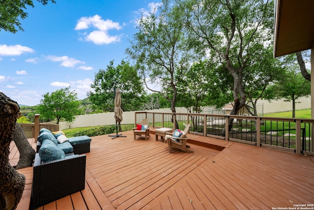 wooden terrace with a fenced backyard and an outdoor living space