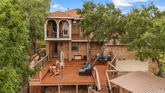back of house with outdoor dining area, a wooden deck, a balcony, and stucco siding