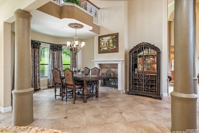 dining room with decorative columns, a towering ceiling, baseboards, tile patterned floors, and a chandelier