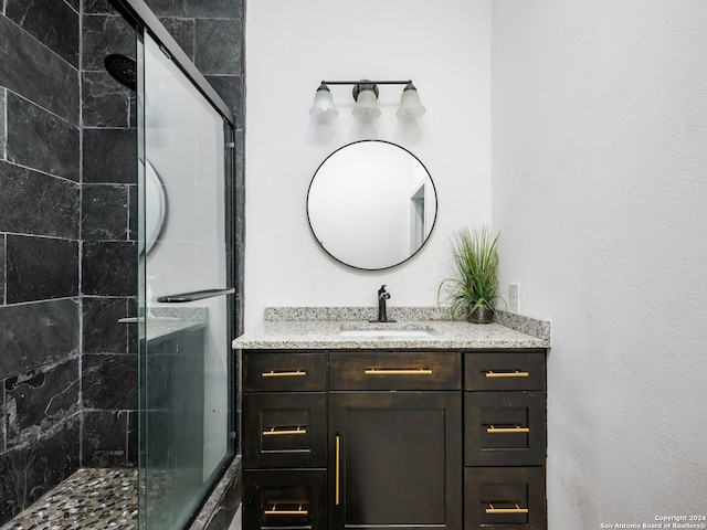 bathroom with a shower stall and vanity