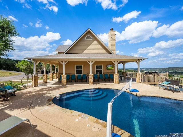 view of swimming pool with a fenced in pool, outdoor dry bar, and a patio