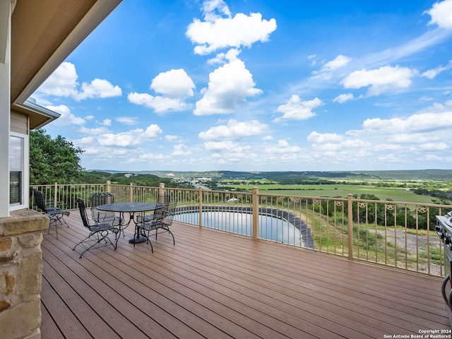 wooden terrace with a water view and outdoor dining area