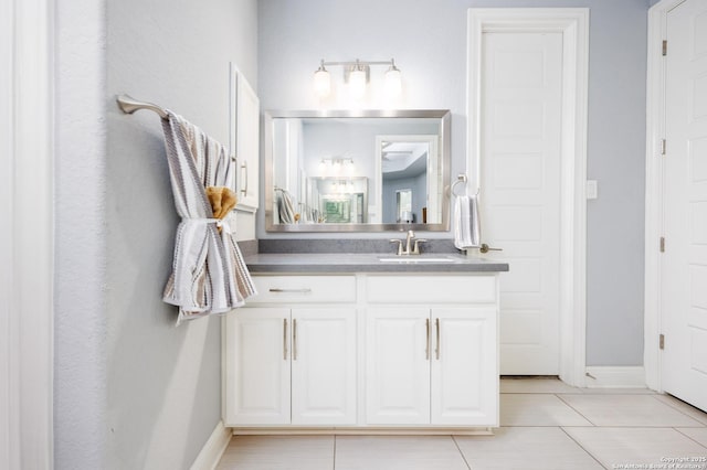 bathroom with vanity, baseboards, and tile patterned floors