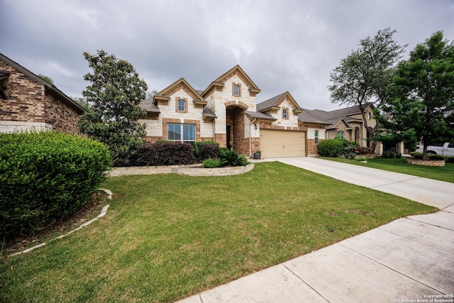 french country home with an attached garage, concrete driveway, a front lawn, and stone siding