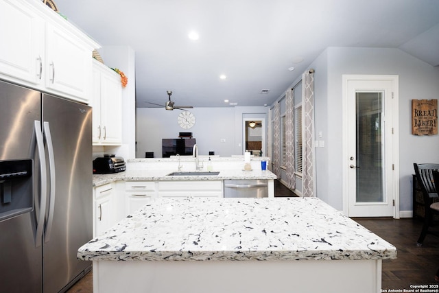 kitchen with a ceiling fan, appliances with stainless steel finishes, a sink, white cabinets, and a peninsula