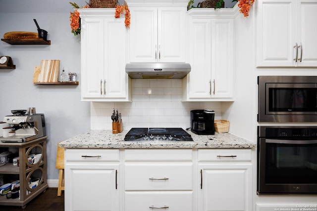 kitchen featuring decorative backsplash, white cabinetry, under cabinet range hood, and stainless steel appliances