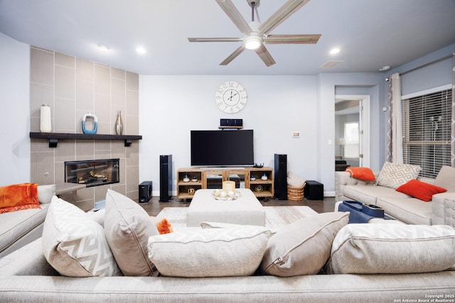 living room with a ceiling fan, a fireplace, wood finished floors, baseboards, and recessed lighting