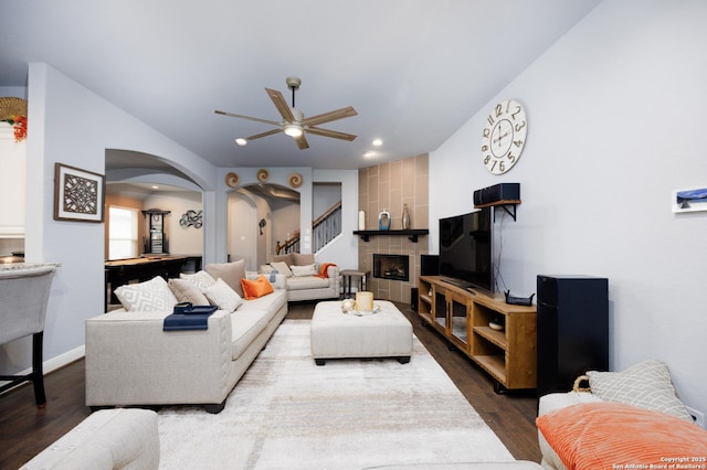 living area featuring arched walkways, a ceiling fan, recessed lighting, and dark wood-style floors