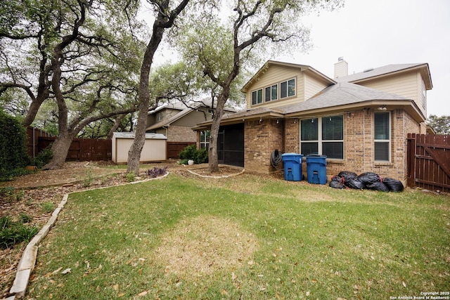 back of property featuring brick siding, a fenced backyard, and a storage unit