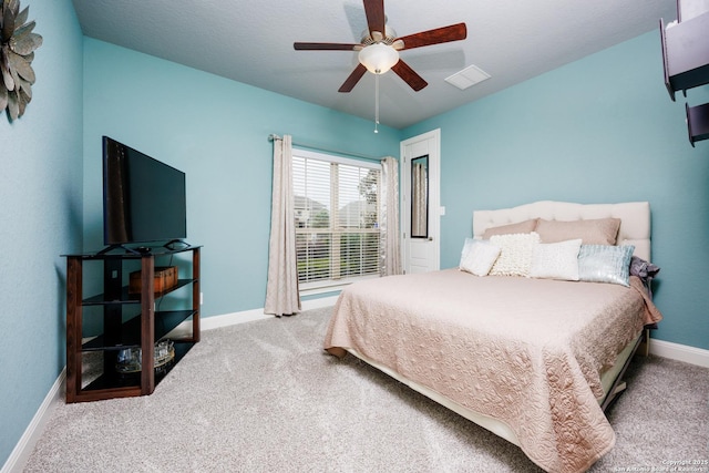 carpeted bedroom featuring baseboards, ceiling fan, and visible vents