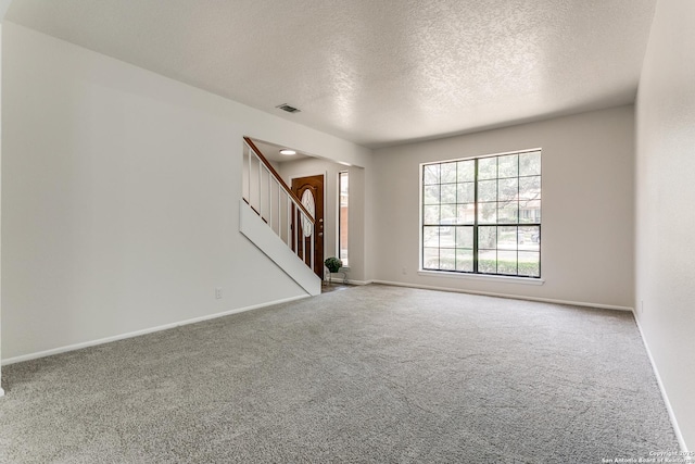 19750 Encino Way, San Antonio, TX 78259 - carpeted empty room featuring stairway, a textured ceiling, and baseboards