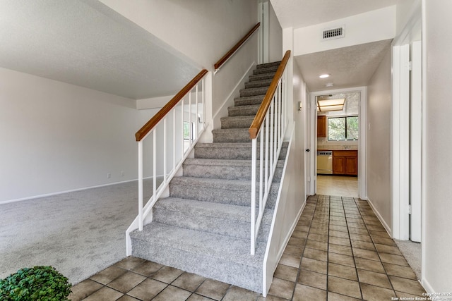 19750 Encino Way, San Antonio, TX 78259 - stairway featuring carpet floors, a textured ceiling, tile patterned floors, and baseboards