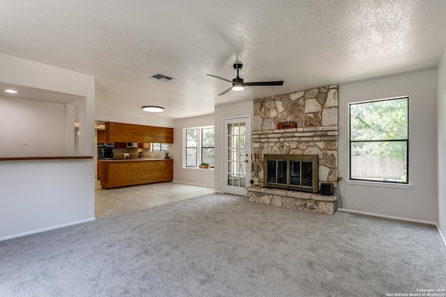 19750 Encino Way, San Antonio, TX 78259 - unfurnished living room featuring a textured ceiling, a ceiling fan, baseboards, carpet flooring, and a fireplace