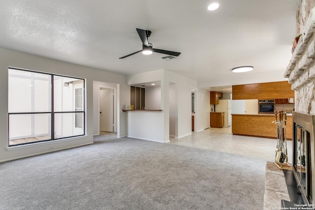19750 Encino Way, San Antonio, TX 78259 - unfurnished living room with a stone fireplace, a ceiling fan, light carpet, and baseboards
