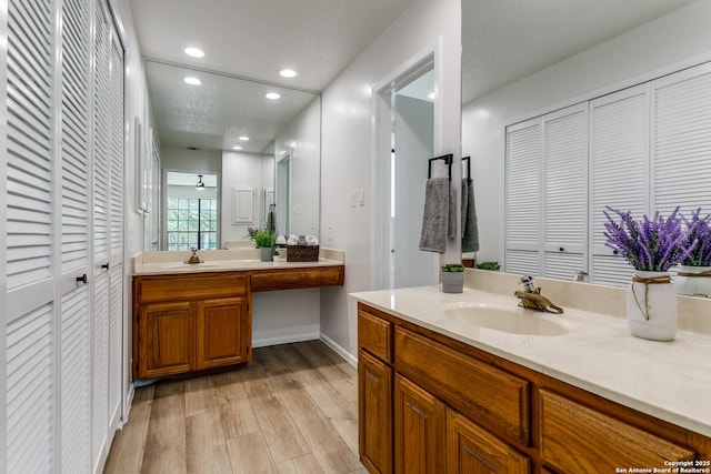19750 Encino Way, San Antonio, TX 78259 - bathroom with a closet, two vanities, wood finished floors, recessed lighting, and baseboards