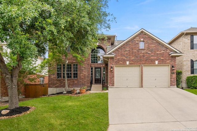 traditional home with a garage, fence, a front yard, brick siding, and driveway