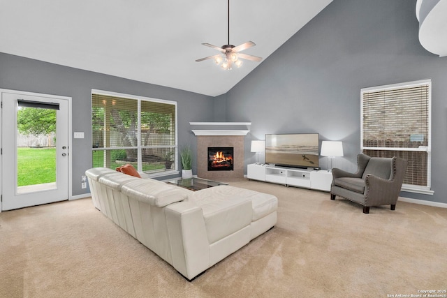 living room featuring carpet floors, a ceiling fan, high vaulted ceiling, and a fireplace