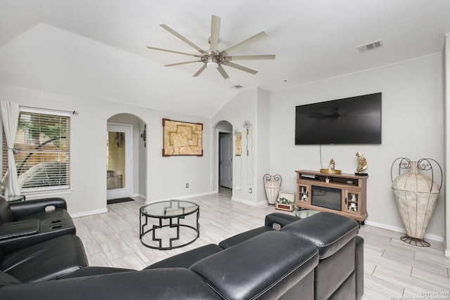 living room featuring arched walkways, a ceiling fan, vaulted ceiling, and visible vents