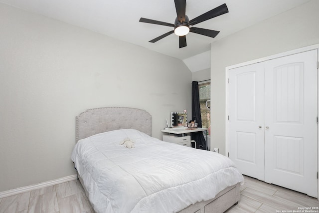 bedroom with a closet, baseboards, ceiling fan, and vaulted ceiling