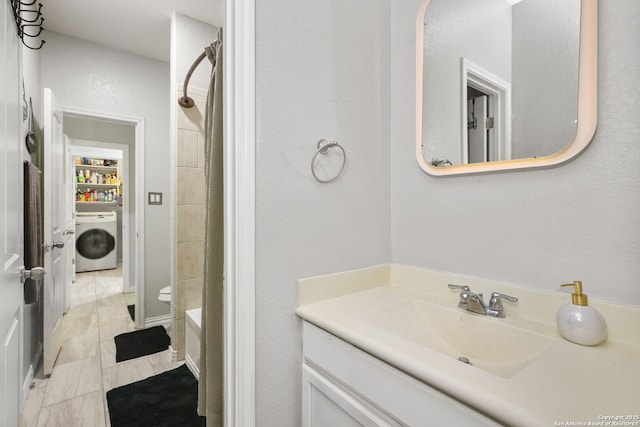bathroom with a shower with curtain, washer / dryer, and vanity
