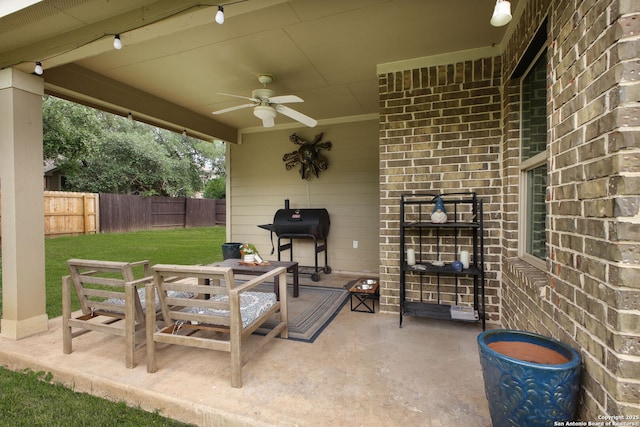 view of patio with area for grilling, ceiling fan, and fence