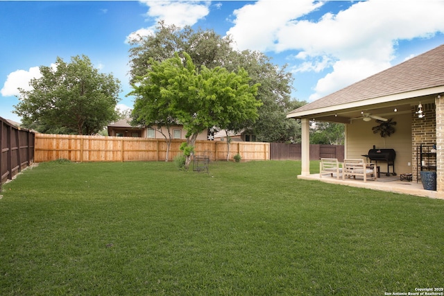 view of yard with a fenced backyard, a ceiling fan, and a patio