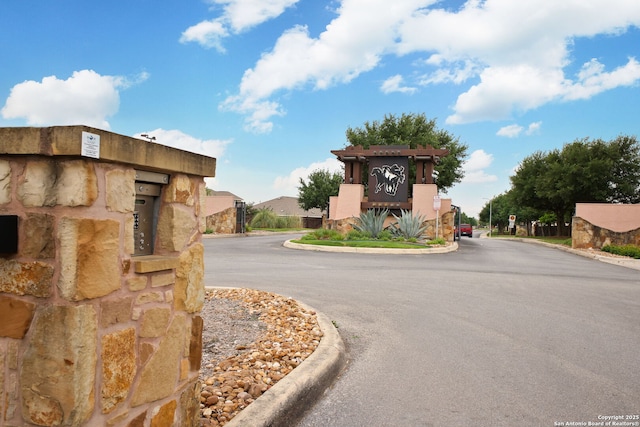 view of road featuring curbs and a gated entry