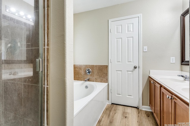5735 Cardinal Fls, San Antonio, TX 78239 - full bath with double vanity, wood finished floors, a bath, a shower stall, and a sink