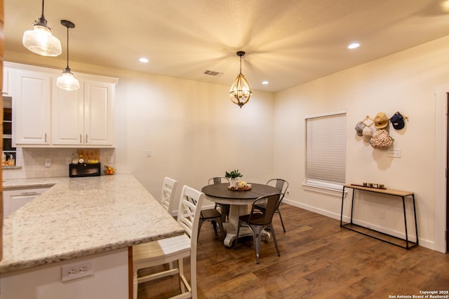 dining room featuring dark wood-style flooring, baseboards, recessed lighting, and visible vents