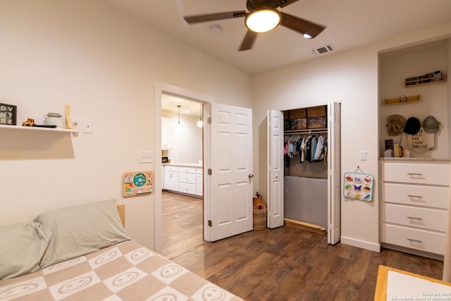 bedroom with visible vents, dark wood finished floors, ceiling fan, and a closet