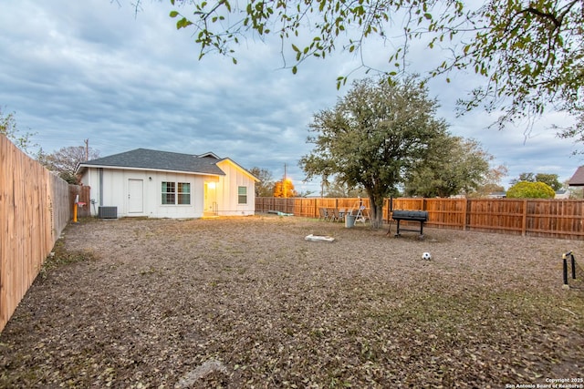 view of yard with central air condition unit and a fenced backyard
