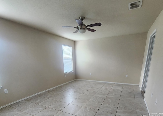 unfurnished room featuring light tile patterned floors, baseboards, a ceiling fan, and visible vents