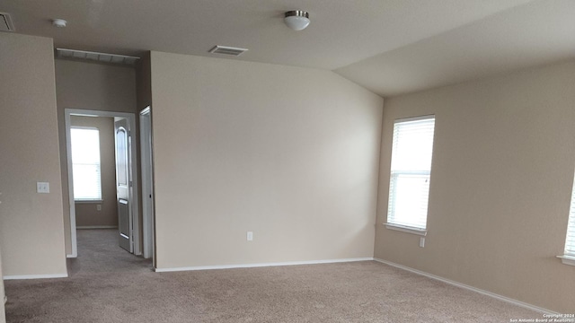 unfurnished room featuring visible vents, carpet flooring, baseboards, and lofted ceiling