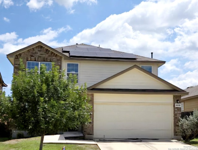traditional home featuring concrete driveway and solar panels