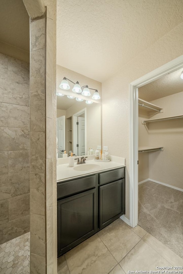 3830 Bogie Way, Converse, TX 78109 - full bath featuring a walk in closet, a textured ceiling, tile patterned flooring, vanity, and tiled shower