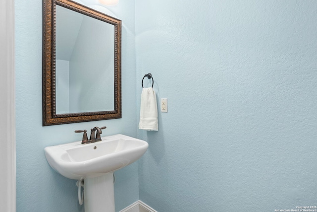 bathroom with baseboards and a textured wall