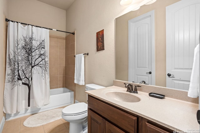 full bathroom featuring a textured wall, tile patterned flooring, vanity, toilet, and shower / bath combo with shower curtain