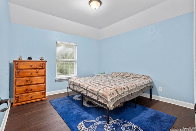 bedroom featuring dark wood-type flooring and baseboards