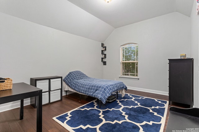 bedroom with baseboards, wood finished floors, and lofted ceiling