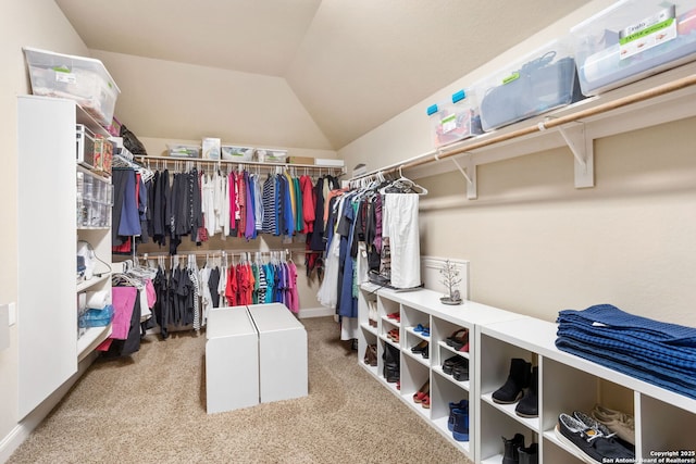 walk in closet with carpet and lofted ceiling