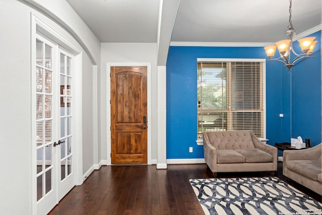 foyer entrance featuring crown molding, baseboards, wood-type flooring, and a chandelier